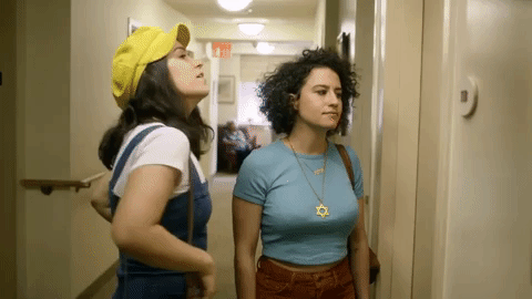 Broad City - Ilana giving Abbi's yellow hat side-eye