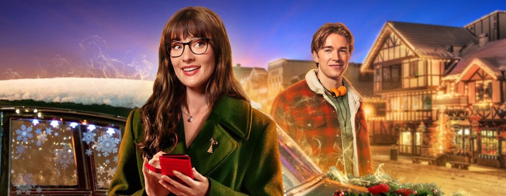 Woman in a green coat with glasses holds a red phone, smiling, in a festive holiday town backdrop with a man in plaid jacket.