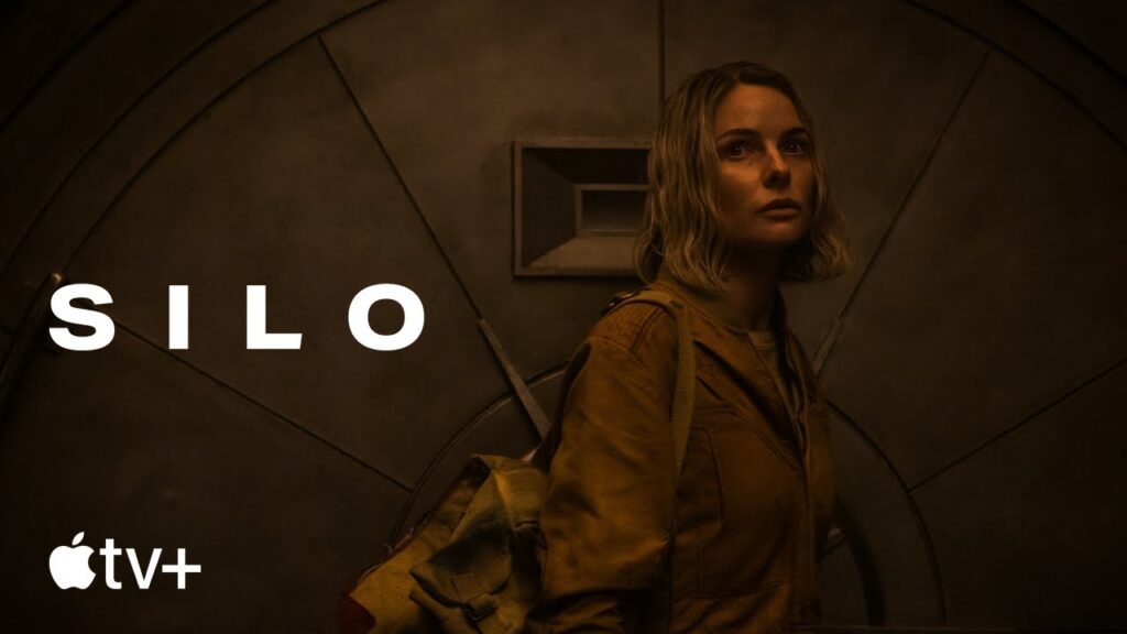 Poster for Silo (Apple TV+): a woman with a backpack in a dim, industrial setting with the title 'SILO' visible.