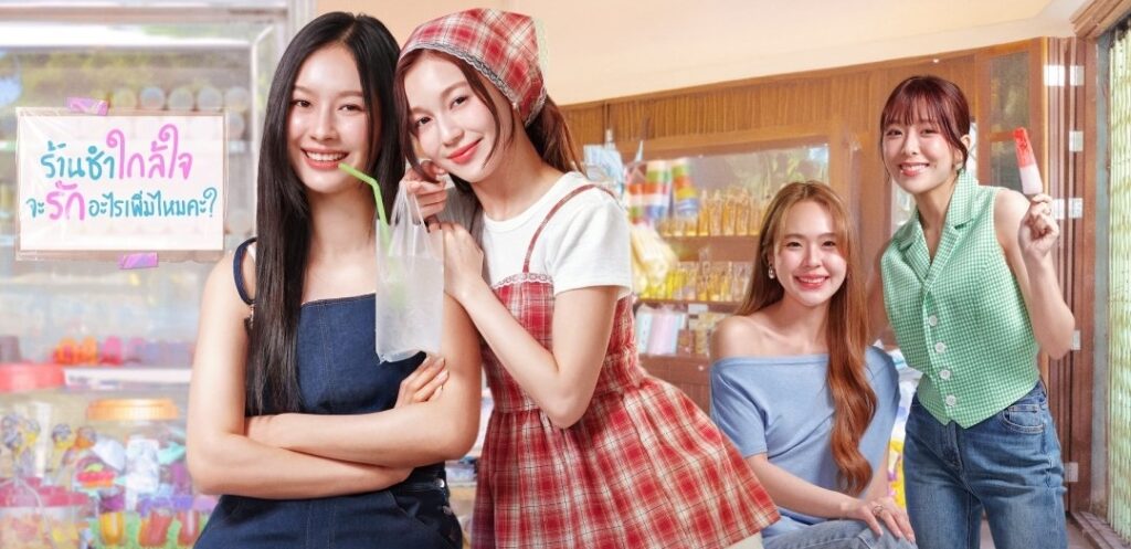 Four young women pose cheerfully in a colorful candy shop; one in denim overalls holds a drink, another in a red plaid dress leans in, a woman in a blue off‑shoulder top sits smiling, and a fourth stands with a popsicle.