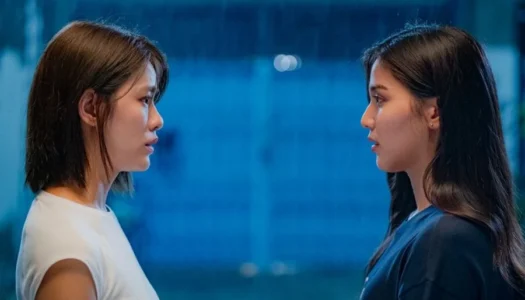 Two women in profile facing each other, talking in a blue-lit space.