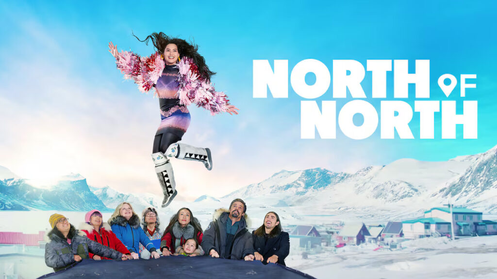 Promotional banner showing a woman in a colorful outfit leaping above a cheering group against a snowy mountain backdrop with the title 'NORTH OF NORTH'.